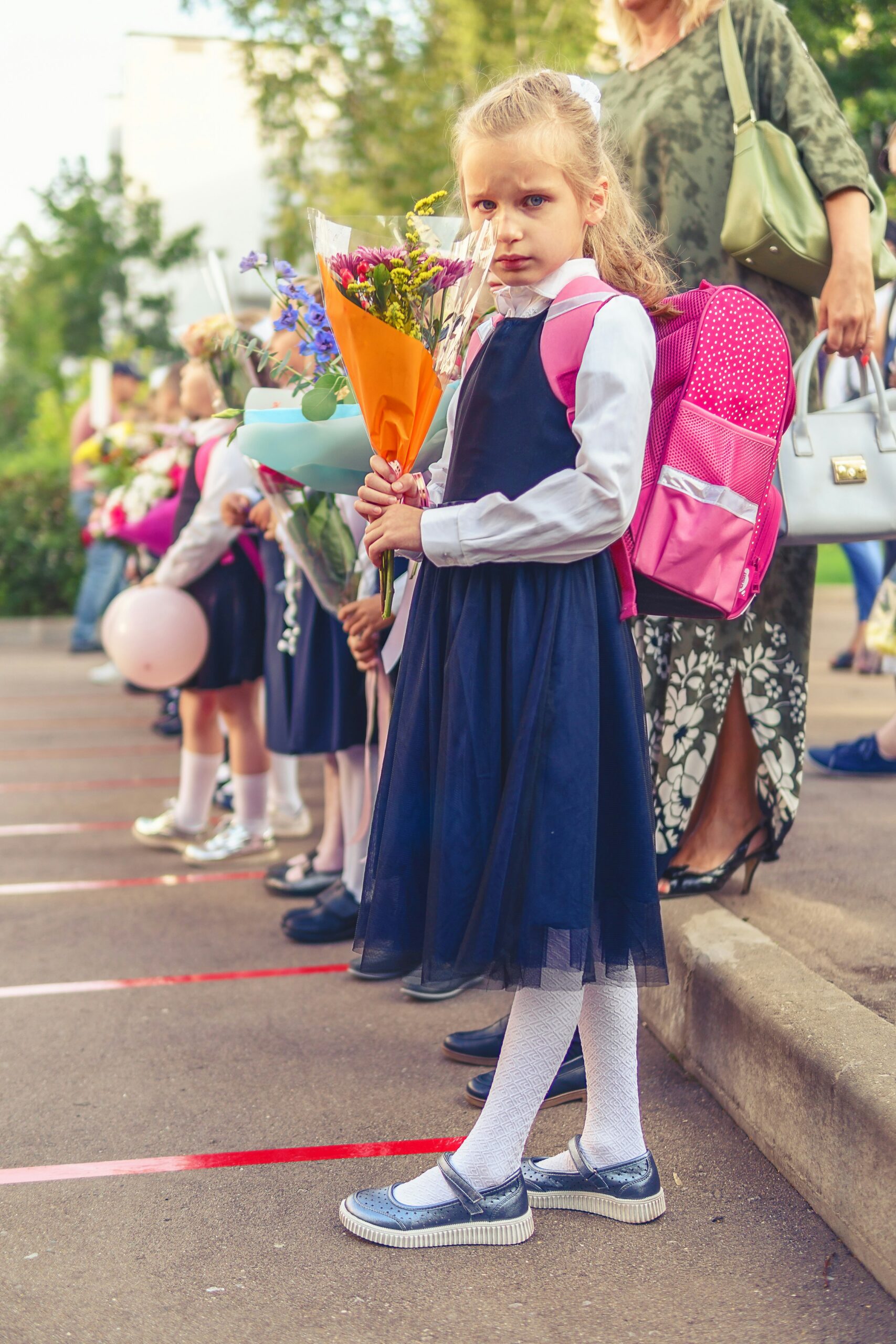 Schulranzen, Tornister – Kind mit buntem Schulranzen freut sich am ersten Schultag