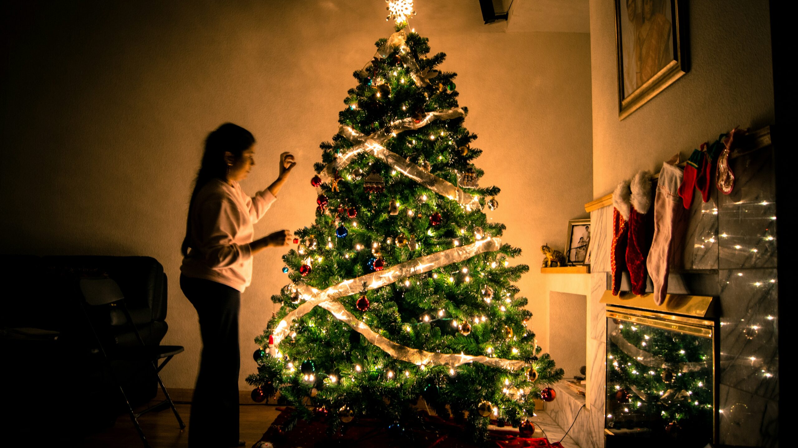 Weihnachten mit Kindern organisieren — gemütlicher Familienabend mit Weihnachtsbaum und warmem Licht